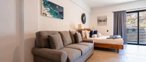 A modern bedroom with a sofa, a bed, and artwork on the walls.