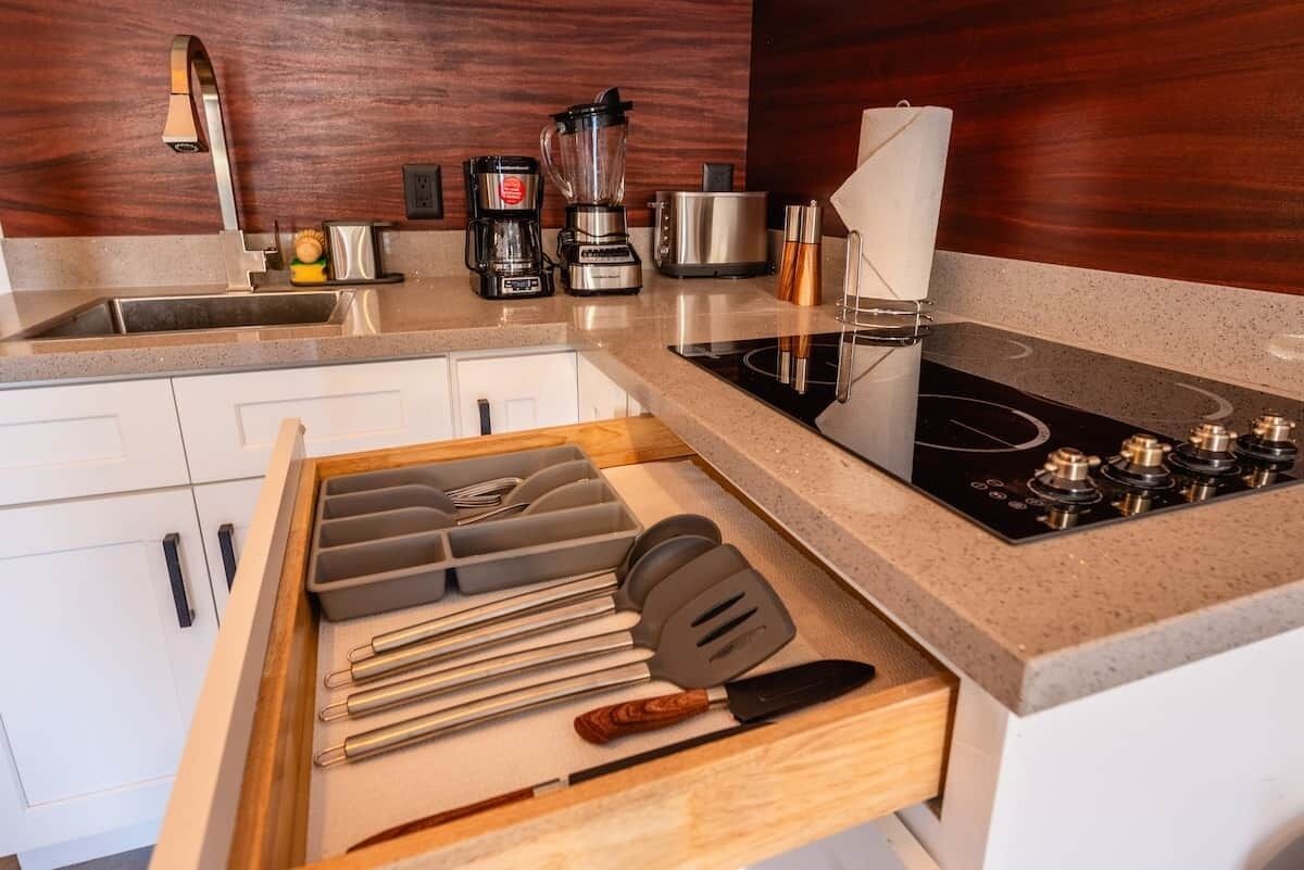 A kitchen with a built-in stove, a coffee maker, and a blender.