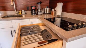 A kitchen with a built-in stove, a coffee maker, and a blender.