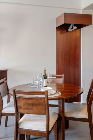 A round wooden dining table with four chairs, a bottle of wine, and several glasses. - New Listing Luxury Stay in Cabo San Lucas (Cabo San Lucas)