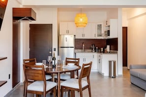 A modern kitchen with white cabinets, a stainless steel refrigerator, and a hanging light fixture. - New Listing Luxury Stay in Cabo San Lucas (Cabo San Lucas)