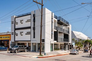 A multi-story building with commercial spaces on the ground floor, including a visible storefront. - New Listing Luxury Stay in Cabo San Lucas (Cabo San Lucas)