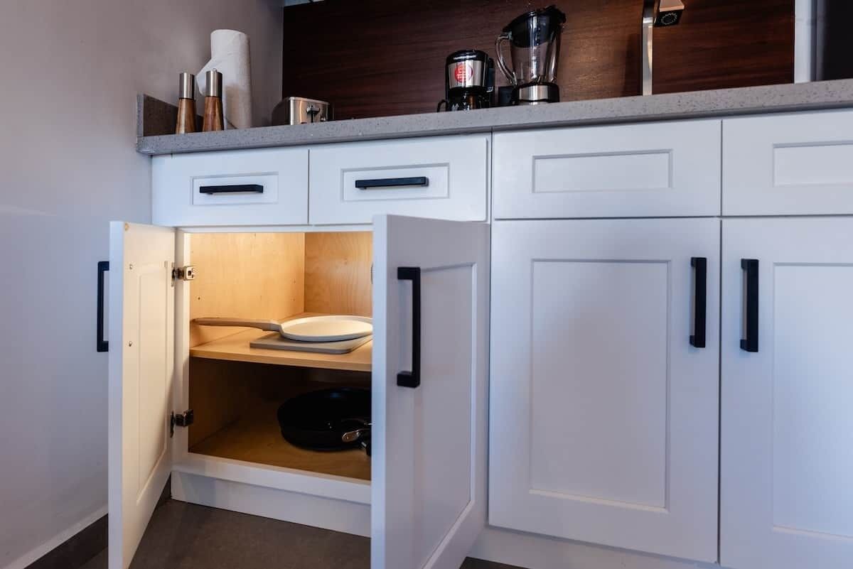 A kitchen with white cabinets, a countertop, and a built-in oven.