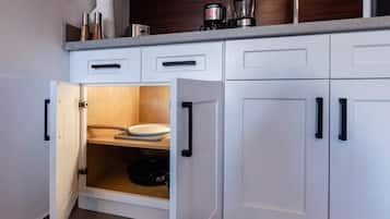 Una cocina con armarios blancos, una encimera y un horno empotrado.