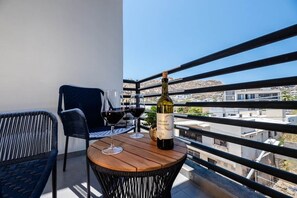 A balcony with a table, two chairs, and a bottle of wine. - New Listing • Prime Location • Cozy & Modern (Cabo San Lucas)
