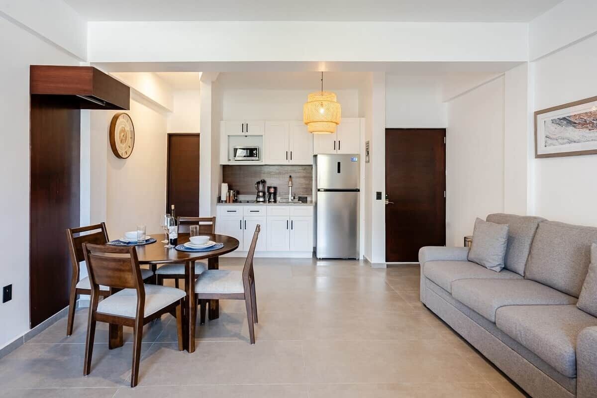 Un salon moderne avec un canapé et un coin repas comprenant des chaises et une table.