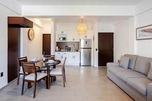 Ein modernes Wohnzimmer mit einer Couch und einem Essbereich mit Stühlen und einem Tisch.