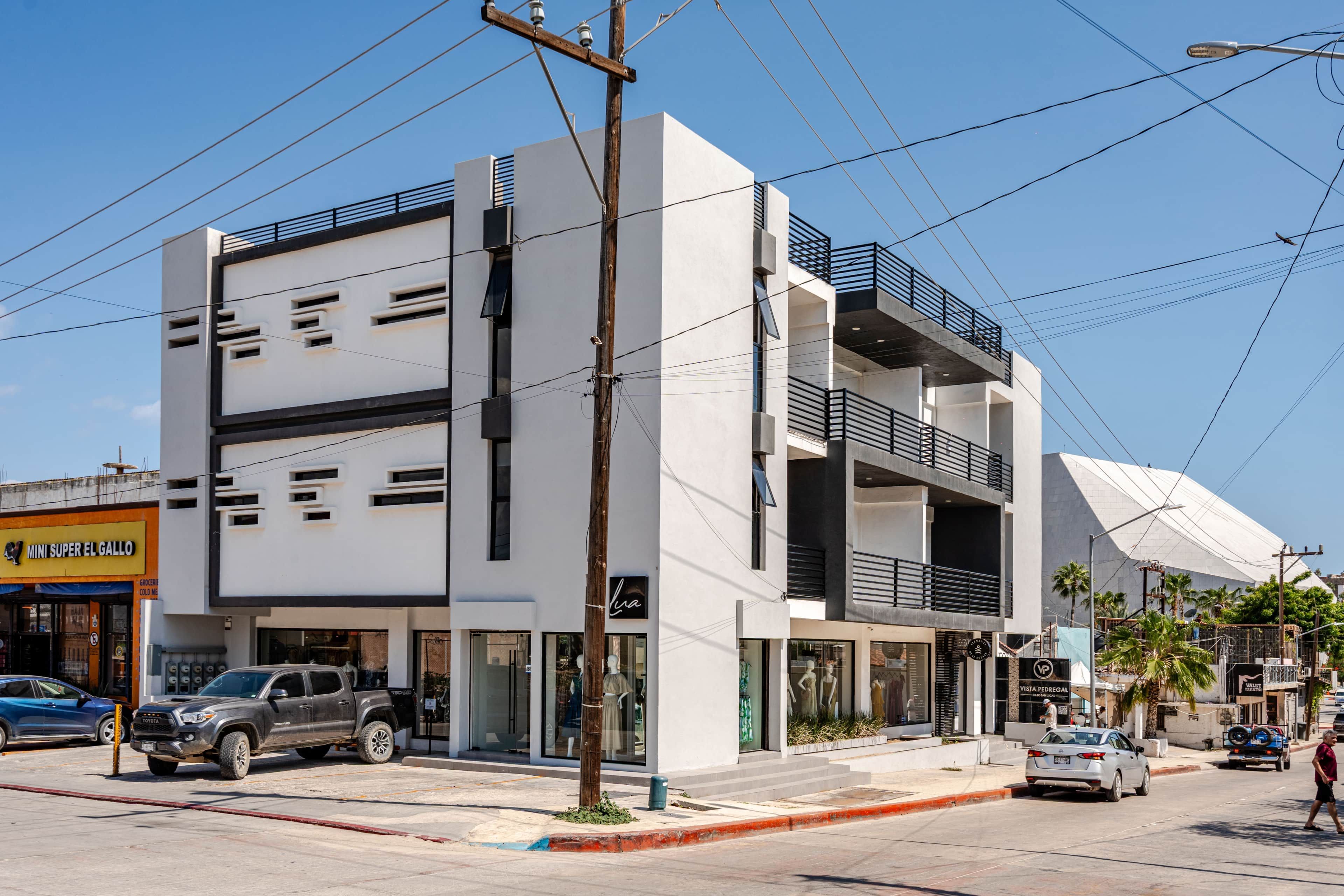 A multi-story building with commercial spaces on the ground floor, including a visible storefront.