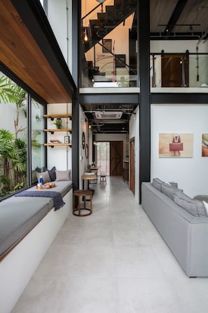 A modern interior with a mezzanine level, built-in seating, and artwork on the walls.