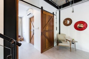 A modern interior with a sliding barn door, a small round table with a chair, and decorative wall art.