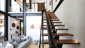 Un interior moderno con una escalera, un sofá y un comedor.