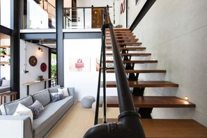 Ein modernes Interieur mit einer Treppe, einer Couch und einem Essbereich.