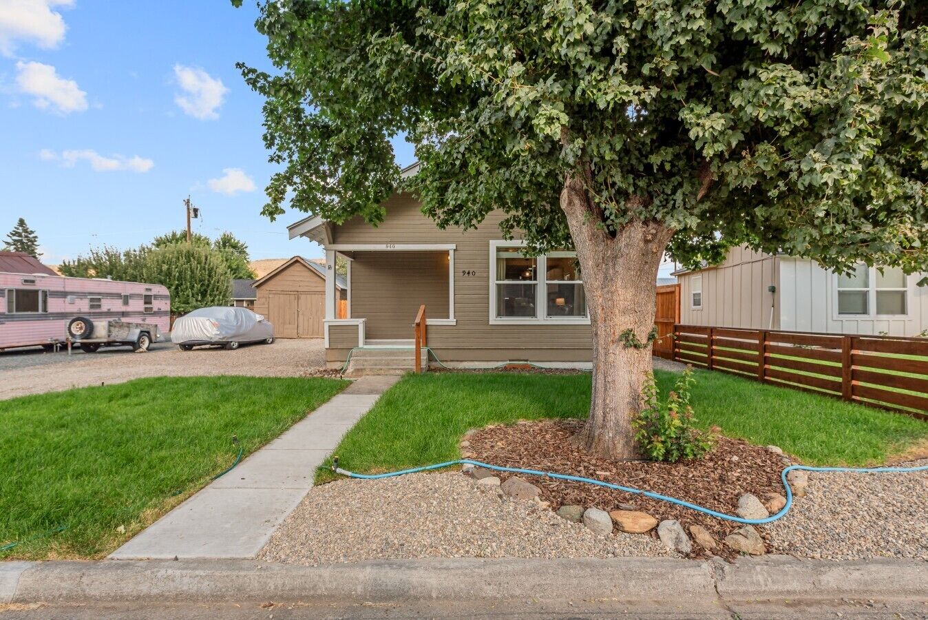 A single-story house with a front yard, a driveway, and a covered parking area.