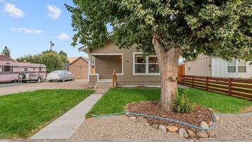 A single-story house with a front yard, a driveway, and a covered parking area.