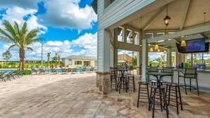 A covered outdoor area with a pool, bar, and seating. - Spacious 5-bedroom house in charming Kissimmee with AC (Kissimmee)