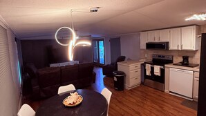Une cuisine moderne avec des meubles blancs, un four à micro-ondes et un lave-vaisselle.