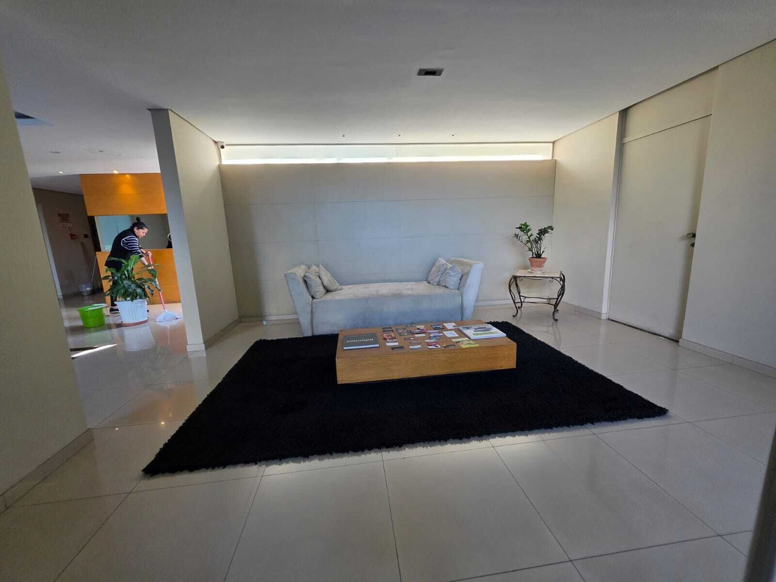 Uma sala de estar moderna com um sofá, uma mesa de centro e um vaso de planta.