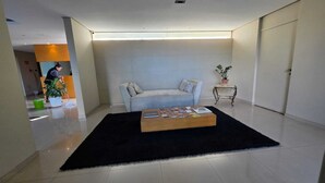A modern living room with a sofa, a coffee table, and a potted plant. - Duplex Apartment: Style and comfort just a few meters from Berrini & Shopping (São Paulo)