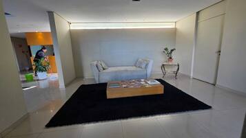 Uma sala de estar moderna com um sofá, uma mesa de centro e um vaso de planta.