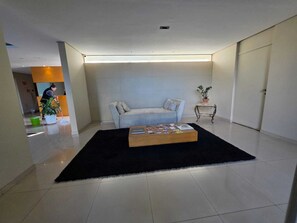 A modern living room with a sofa, a coffee table, and a potted plant. - Duplex Apartment: Style and comfort just a few meters from Berrini & Shopping (São Paulo)