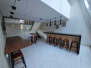 A modern kitchen with a central island, bar stools, and pendant lighting. - Duplex Apartment: Style and comfort just a few meters from Berrini & Shopping (São Paulo)