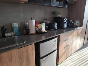 A modern kitchen with a stainless steel sink, a coffee maker, a toaster, and a refrigerator. -  Luxurious and Modern, Menlyn Maine Residences 825, Pretoria (Pretoria)
