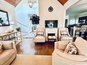 A living room with a fireplace, a television, and a staircase leading to another level. - Panoramic Views of KY Lake.  (Buchanan)