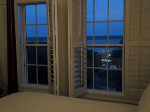 A room with a large window, a bed, and a view of a cityscape at dusk. - Panoramic Views of KY Lake.  (Buchanan)