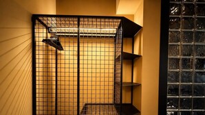 A room with a black metal grid partition, a wooden floor, and a glass door with a grid pattern.