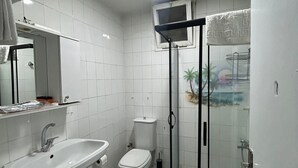 A bathroom with a sink, toilet, and shower area. - No 19 By Suite Daire (Istanbul)