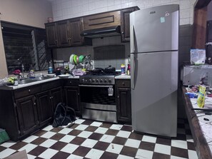 A kitchen with a refrigerator, stove, oven, and a dishwasher.