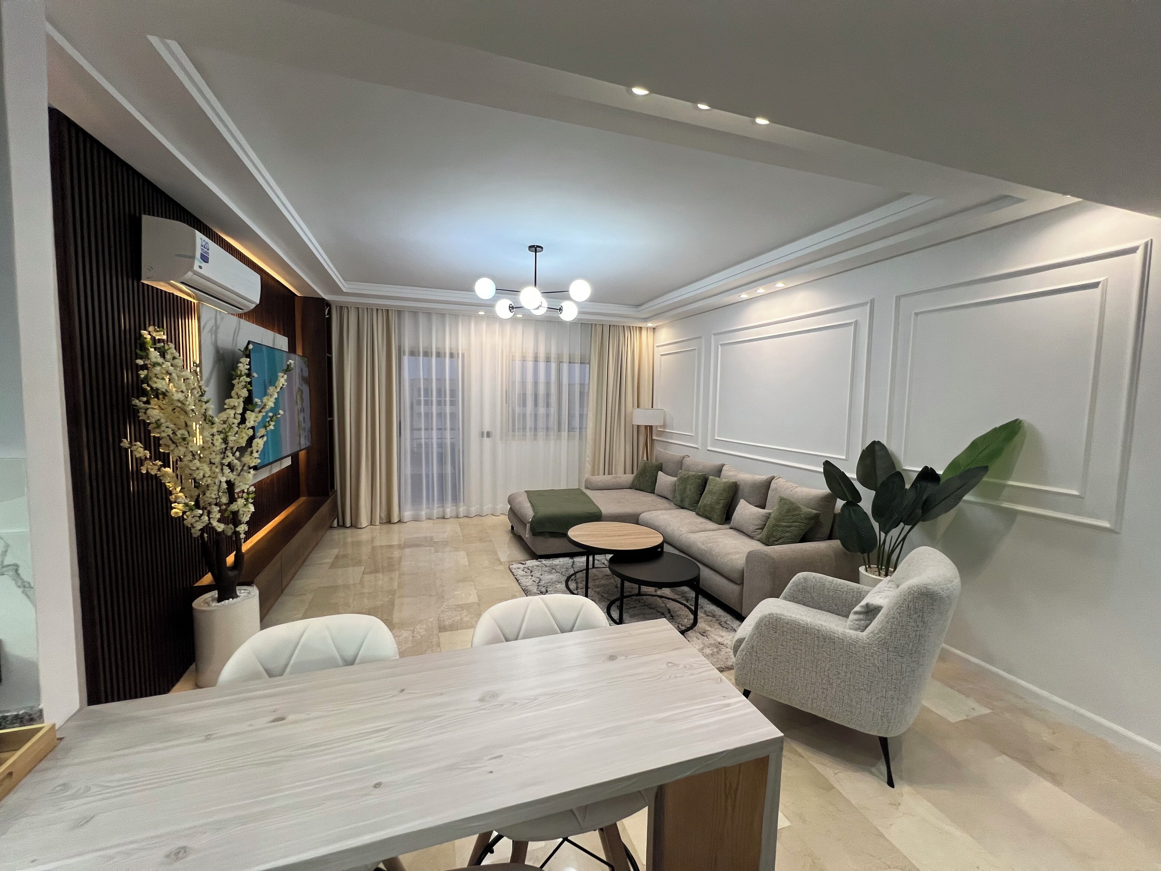 A modern living room with a sectional sofa, a dining table, and a coffee table.