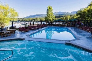 A swimming pool with lounge chairs and a view of a lake and mountains. - Hot Tub, Fireplace, Spacious Deck & Serene Views (Whitefish)