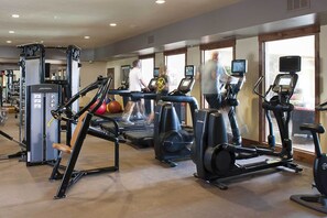 Gimnàs amb cintes de córrer, el·líptiques i equipament de musculació.