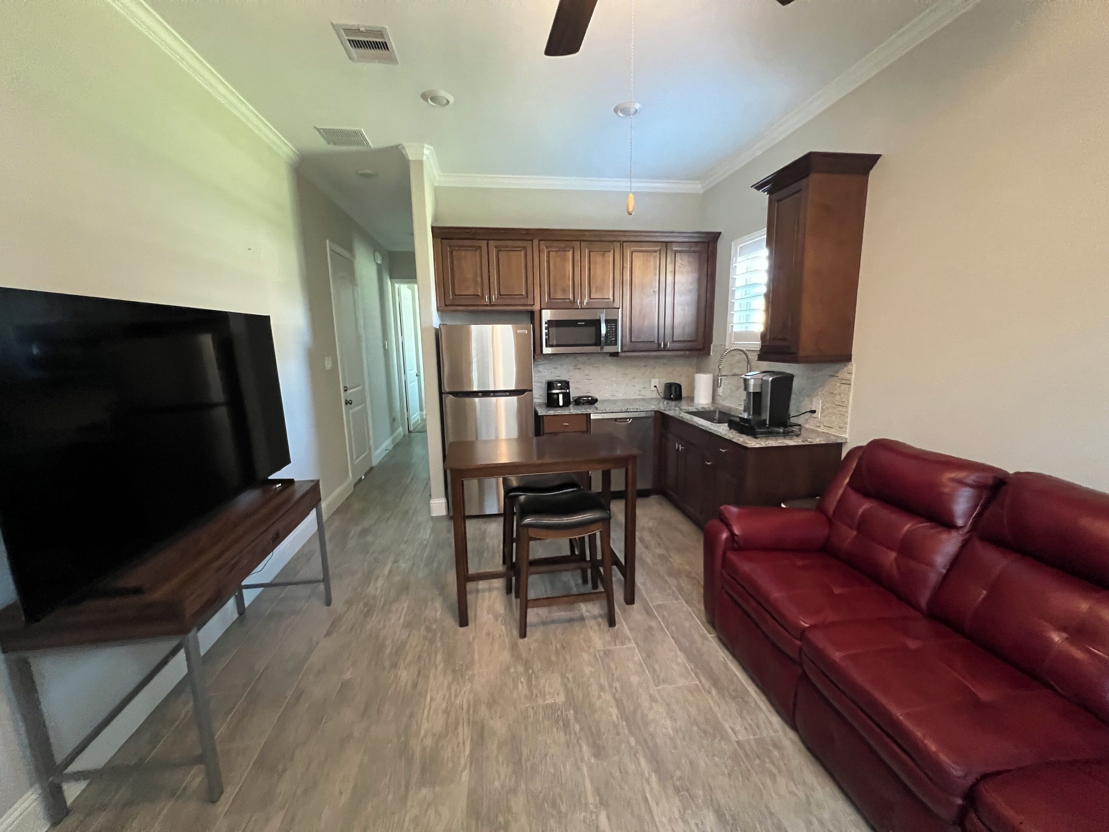 A modern kitchen with wooden cabinets, a stainless steel refrigerator, and a microwave.