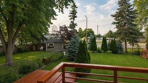 A wooden deck with a view of a well-maintained lawn, a small shed, and a tall tree. - Upscale 3 Bedroom Modern Home: Brand-New Luxury Flooring & Extra Large Backyard (Mississauga)