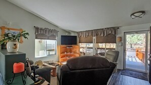 Una sala de estar con televisor, chimenea, mesa de comedor y sofá.
