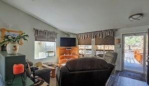 A living room with a television, a fireplace, a dining table, and a sofa. - Forest mountain retreat with resort-style amenities and minutes from Sisters (Sisters)