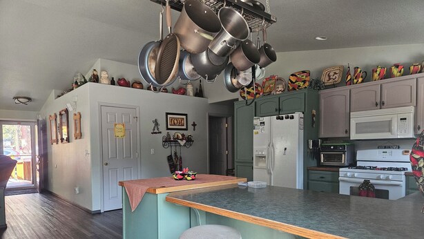 Una cocina con una isla central, electrodomésticos de acero inoxidable y diversos objetos decorativos.