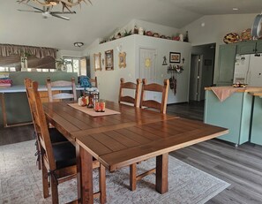A dining area with a wooden table and chairs, a kitchen in the background, and a ceiling fan. - Forest mountain retreat with resort-style amenities and minutes from Sisters (Sisters)