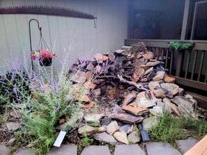 A garden with a stone fire pit surrounded by rocks and plants. - Forest mountain retreat with resort-style amenities and minutes from Sisters (Sisters)
