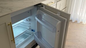Ein offener Kühlschrank mit mehreren Ablagen und einem Gefrierfach.