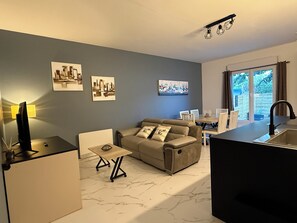 A modern living room with a sofa, a coffee table, and artwork on the walls. - Cozy apartment 2 minutes from the ocean (Fouesnant)