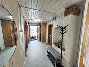 A hallway with wooden paneling, a bench, a coat rack, and a potted plant. - Glanzhirsch Küblis – nahe Klosters/Davos by Interhome (Küblis)