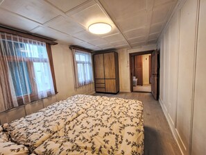 A bedroom with a bed, a wardrobe, and a door leading to another room. - Glanzhirsch Küblis – nahe Klosters/Davos by Interhome (Küblis)