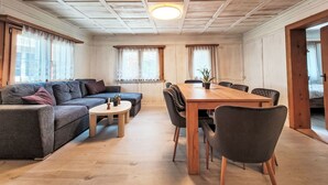 En hyggelig stue med en sofa, et spisebord og stole.