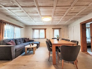 Ein gemütliches Wohnzimmer mit einer Couch, einem Esstisch und Stühlen.