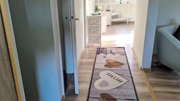 Ein Flur mit einem Teppich, der ein Hausdesign zeigt und das Wort 'HOME' darauf trägt.