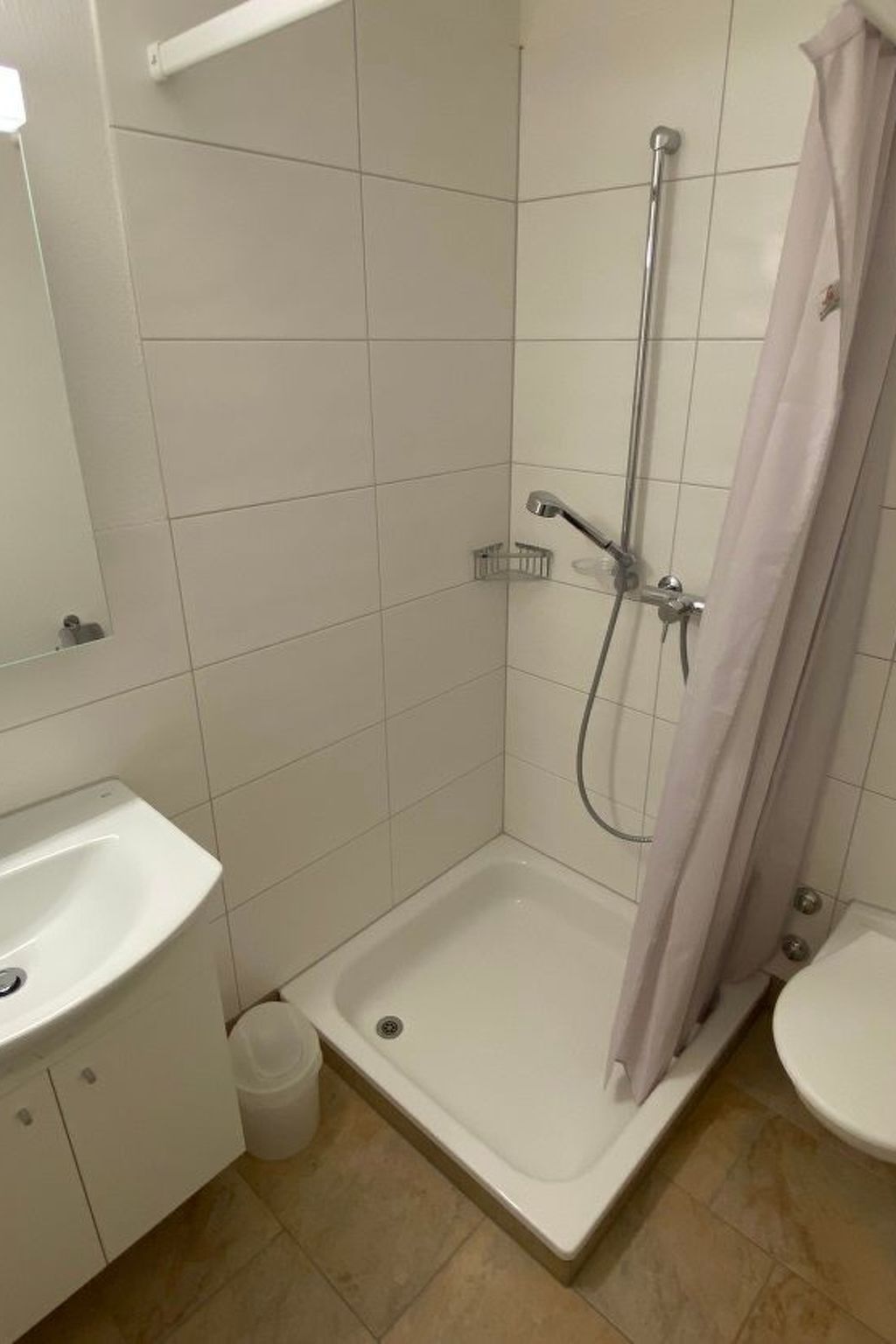 Ein Badezimmer mit Dusche, Waschbecken und Toilette.
