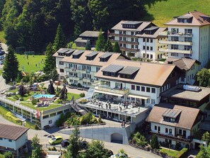 A multi-story hotel with a rooftop pool and outdoor seating area.